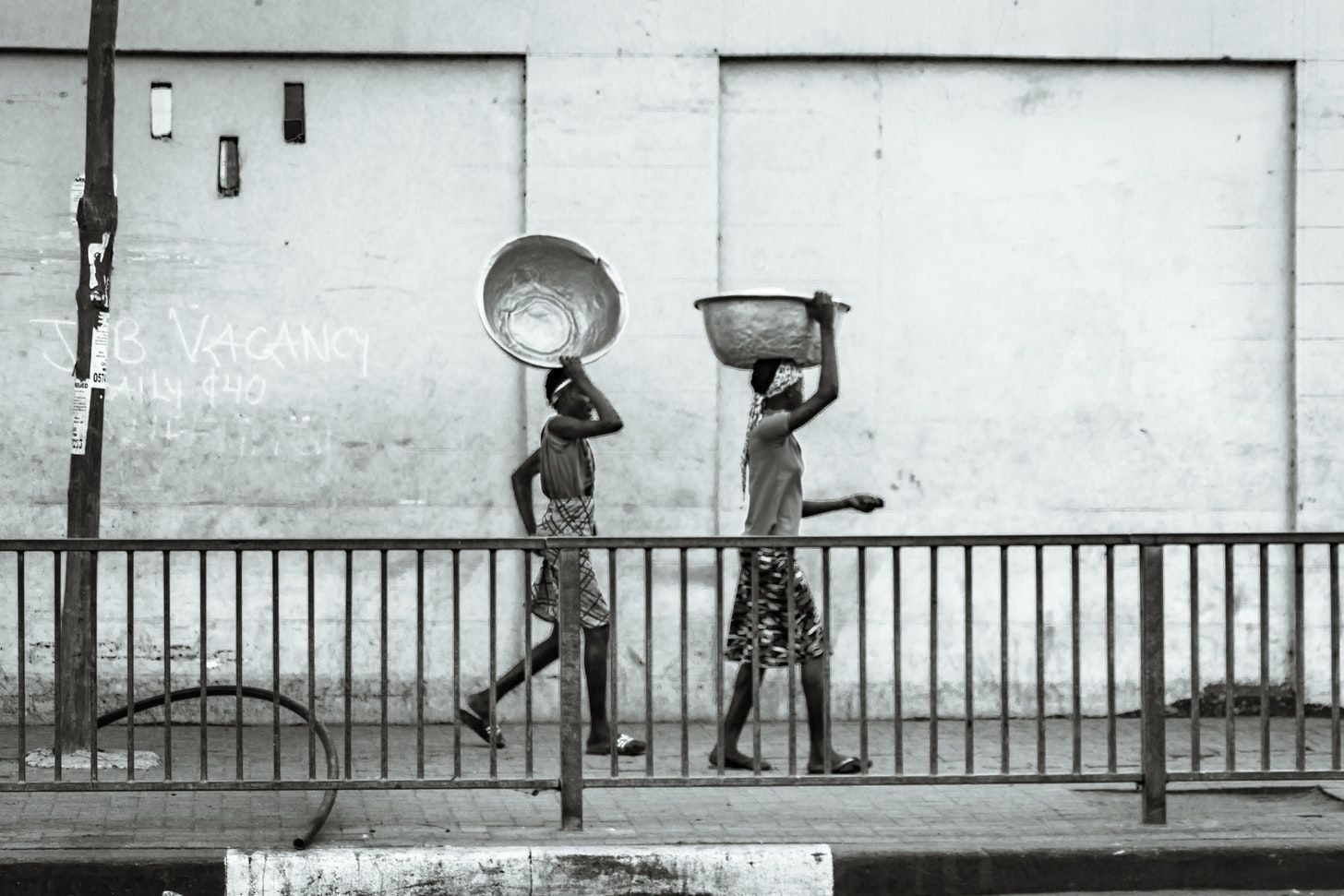 Two women carrying tin basin in Calabar, Nigeria: A photo by David Elikwu