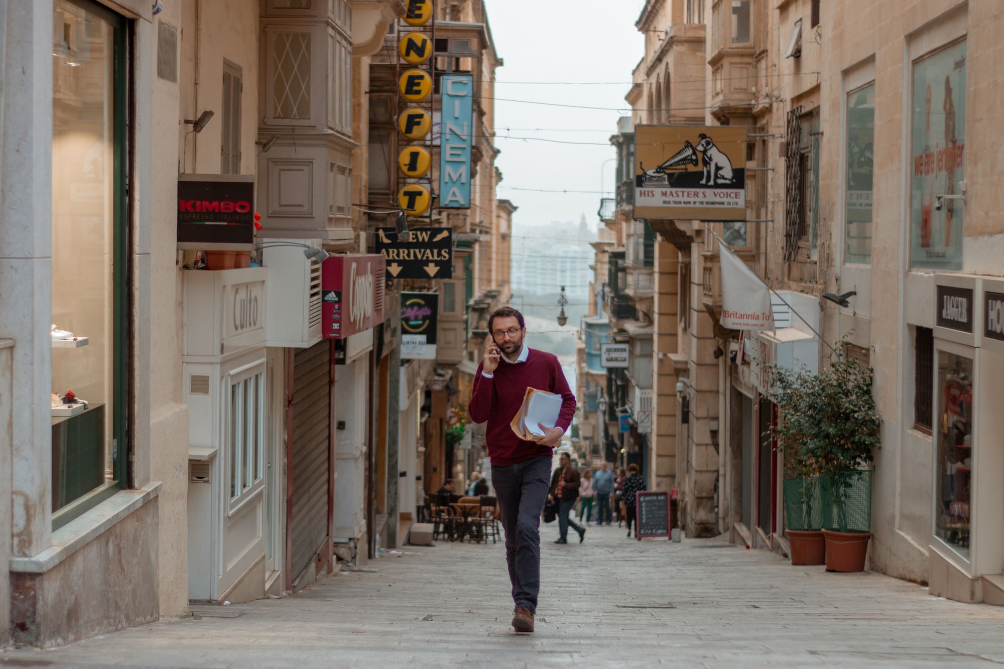 A man walking while talking to someone over his phone in Malta: A photo by David Elikwu